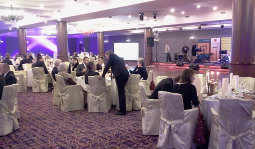 Widok ogólny na stoliki ustawione wokół podium w trakcie gali wręczania nagród projektów Samorząd Równych Szans i Forum Dostępnej Cyberprzestrzeni - Hotel Gołębiewski w Karpaczu.